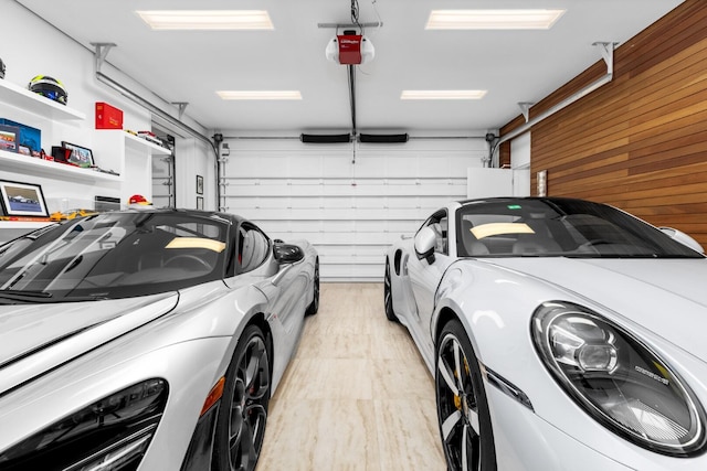 garage with wood walls and a garage door opener