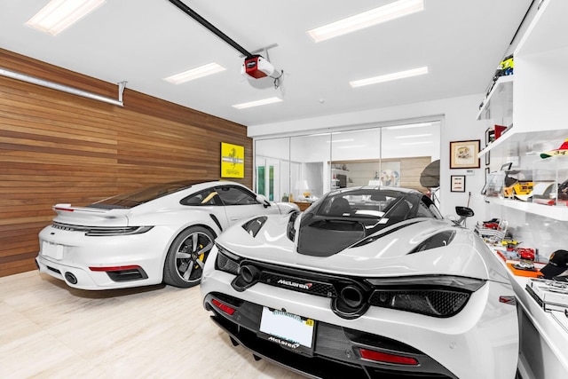 garage with a garage door opener and wood walls