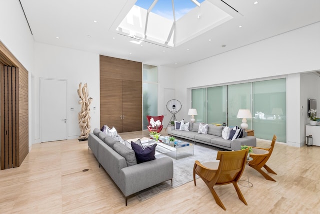 living room featuring a towering ceiling and a skylight