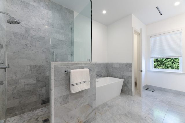 bathroom with separate shower and tub and tile walls