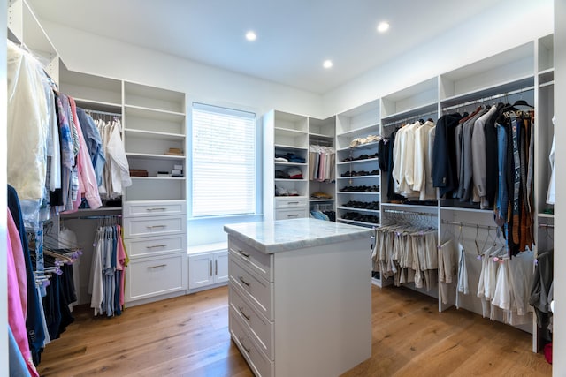 walk in closet with light hardwood / wood-style flooring