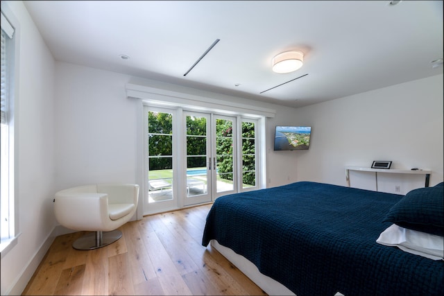 bedroom with french doors, light hardwood / wood-style floors, and access to outside