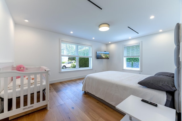 bedroom with multiple windows and light wood-type flooring