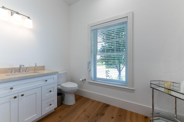 bathroom featuring wood-type flooring, vanity, and toilet