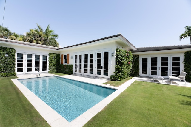 back of property featuring a lawn, french doors, and a patio area