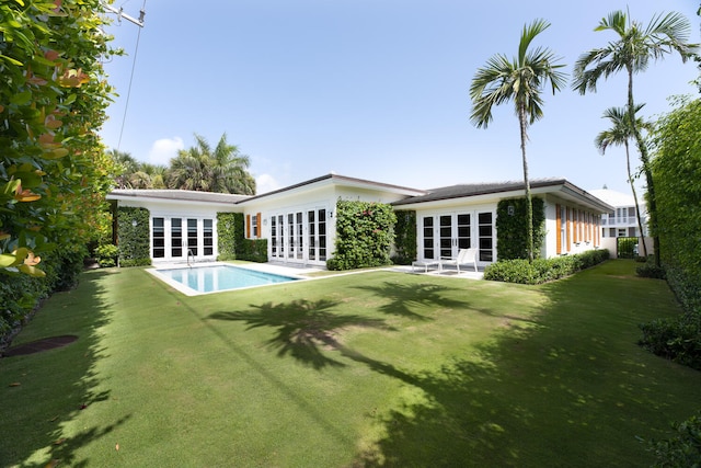 rear view of house with a yard, french doors, and a patio area