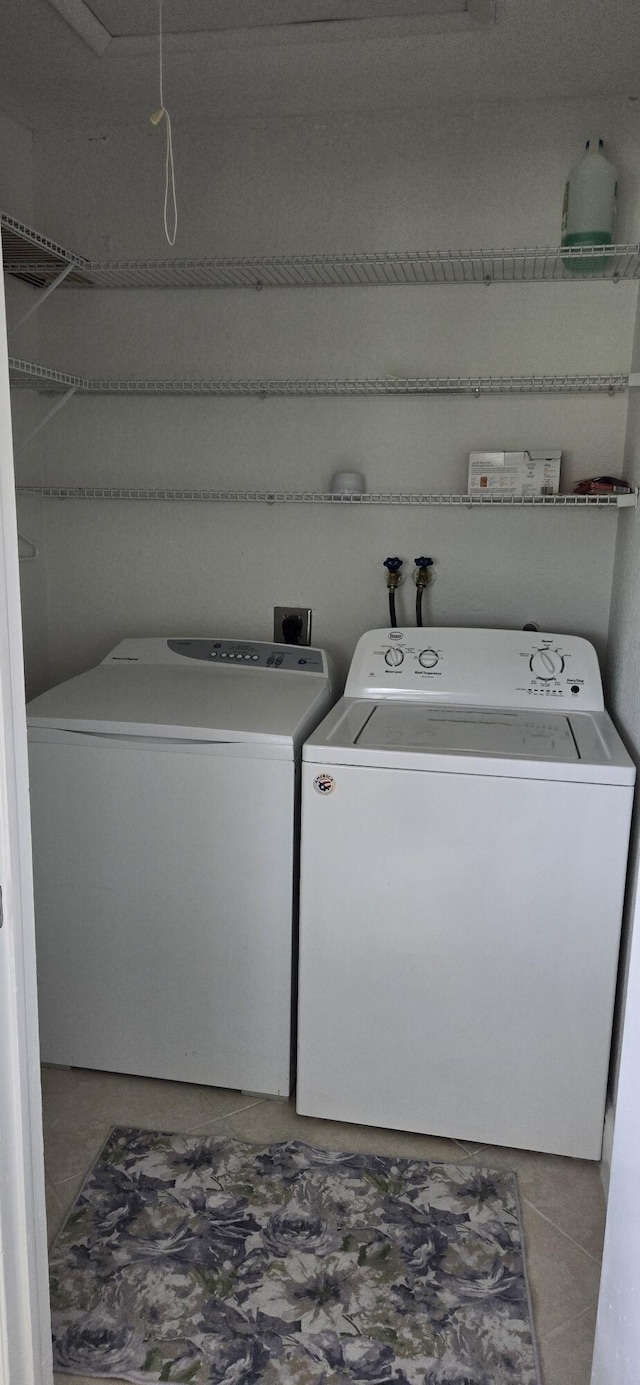 clothes washing area featuring separate washer and dryer and light tile patterned floors