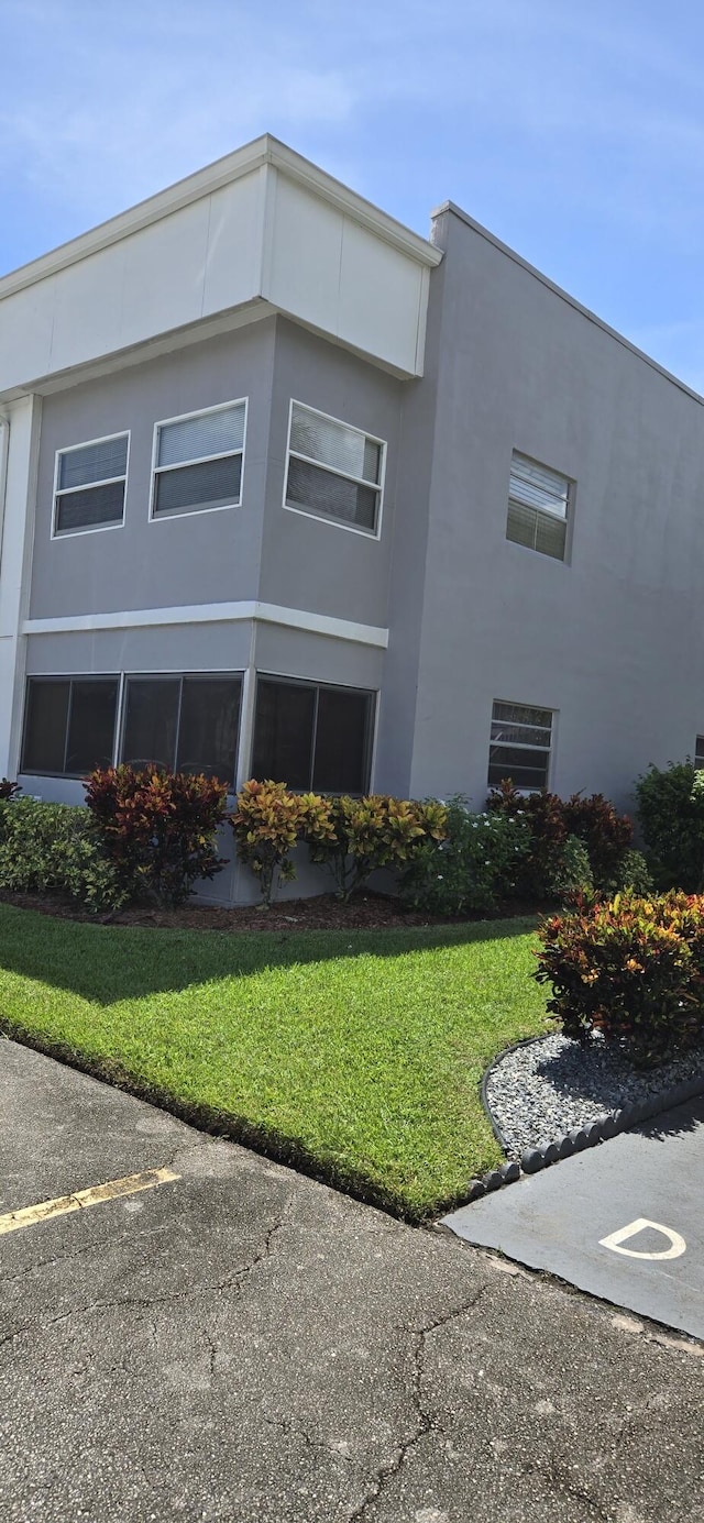 184 Burgundy D, Delray Beach, FL 33484 - view of side of home featuring a lawn and stucco siding