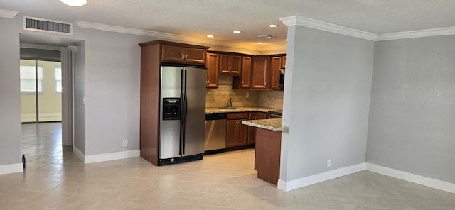 kitchen featuring appliances with stainless steel finishes, light stone counters, sink, tasteful backsplash, and ornamental molding