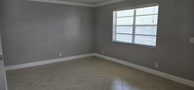 empty room featuring tile patterned floors, crown molding, and a healthy amount of sunlight