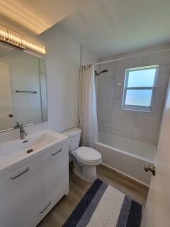 full bathroom featuring vanity, toilet, shower / tub combo with curtain, and hardwood / wood-style floors