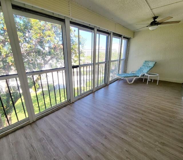 unfurnished sunroom with ceiling fan