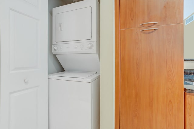 laundry area featuring stacked washer / drying machine