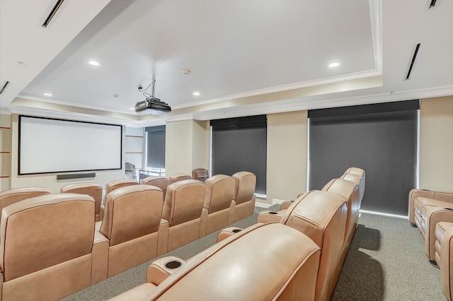 home theater room featuring a tray ceiling, carpet flooring, and ornamental molding