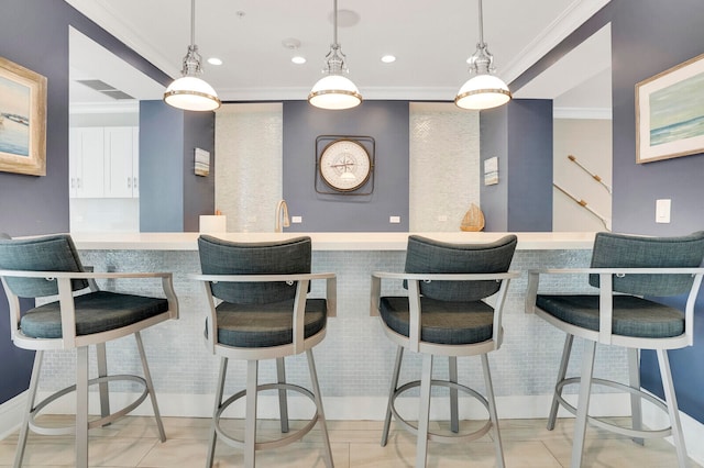 kitchen featuring kitchen peninsula, ornamental molding, white cabinetry, and a breakfast bar area