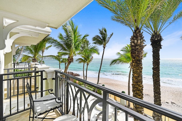 balcony featuring a water view and a view of the beach