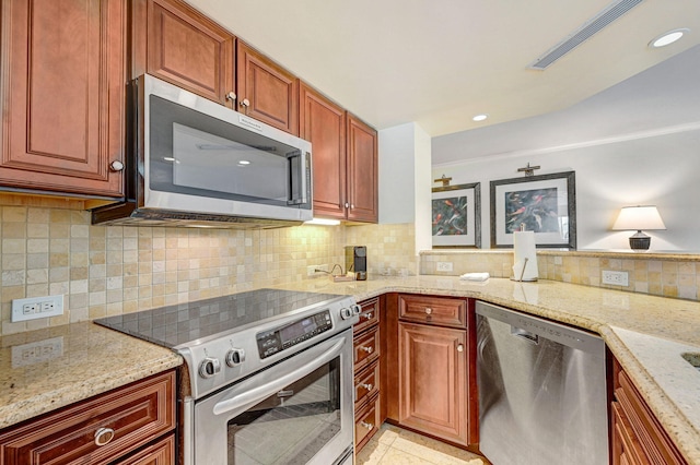 kitchen with decorative backsplash, stainless steel appliances, and light stone counters