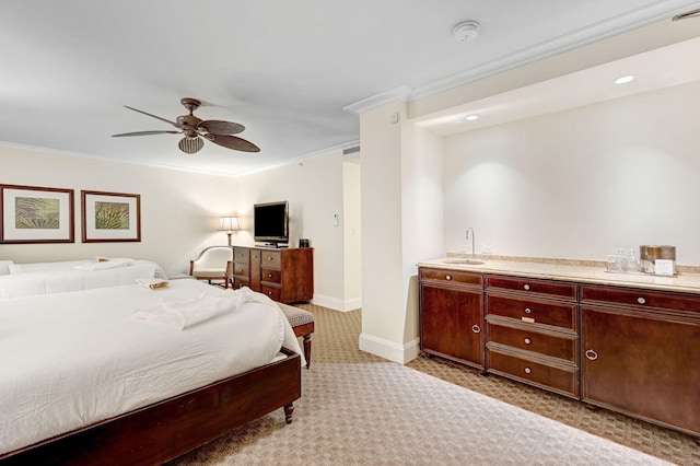 carpeted bedroom featuring ceiling fan, crown molding, and sink