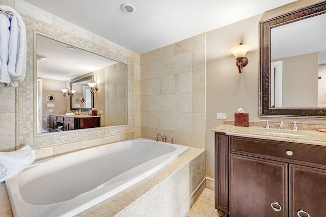 bathroom with tile patterned flooring, vanity, and a relaxing tiled tub