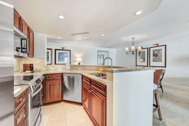 kitchen featuring pendant lighting, a chandelier, sink, kitchen peninsula, and stainless steel appliances