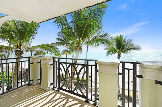 balcony featuring a view of the beach and a water view