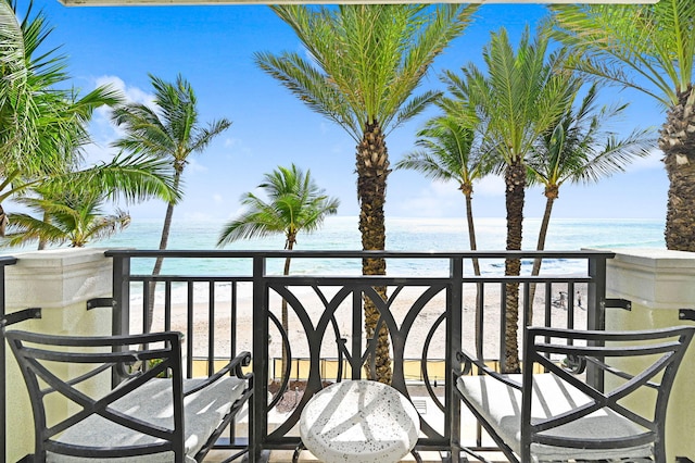 balcony featuring a water view and a beach view