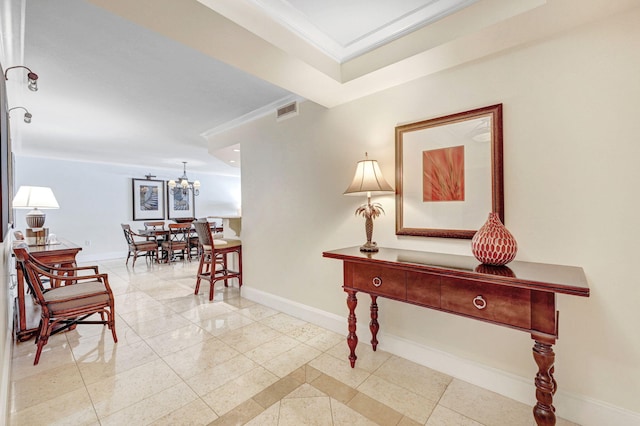 hallway featuring a notable chandelier, crown molding, and light tile patterned flooring