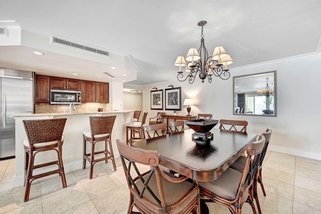 dining room featuring a notable chandelier, light tile patterned floors, and ornamental molding