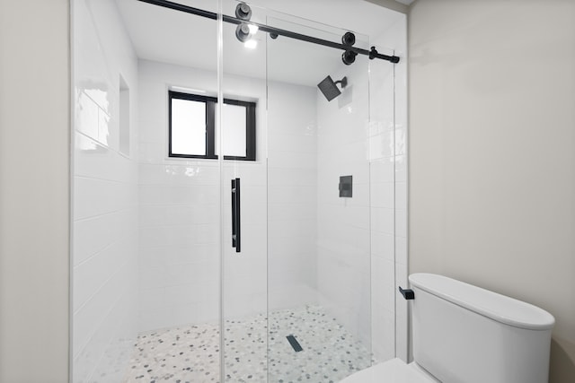 bathroom with toilet and a shower with shower door