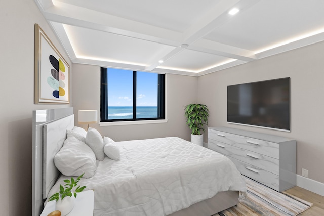 bedroom with light hardwood / wood-style floors, beam ceiling, and coffered ceiling