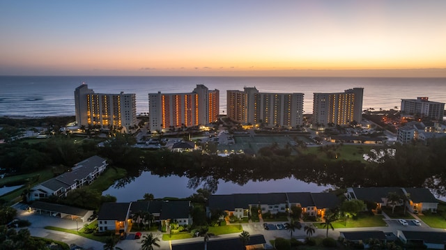 aerial view at dusk featuring a water view