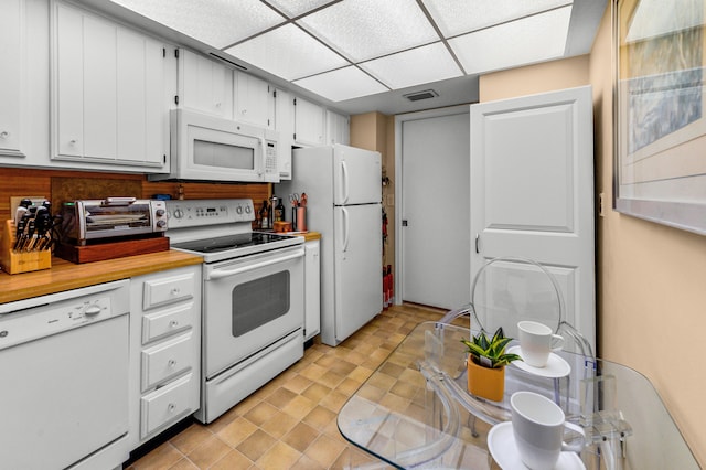 kitchen with white cabinets, white appliances, and a paneled ceiling