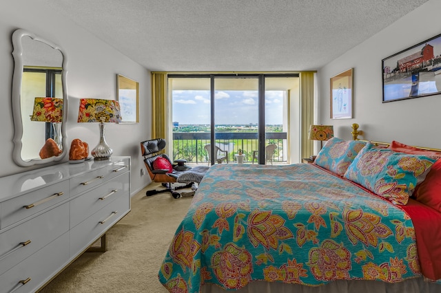 carpeted bedroom featuring a wall of windows, multiple windows, access to exterior, and a textured ceiling