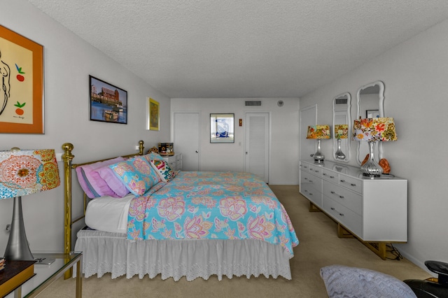 bedroom with light carpet and a textured ceiling