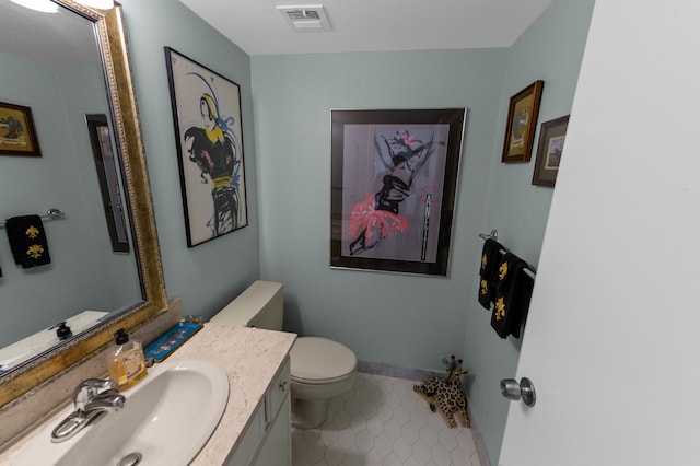 bathroom featuring tile patterned flooring, toilet, and vanity