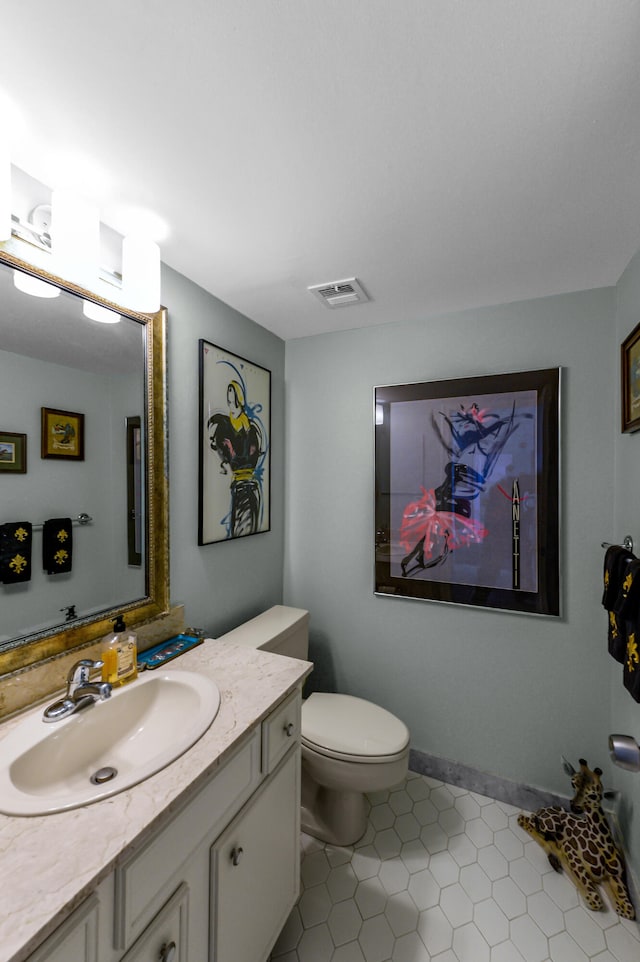 bathroom with tile patterned flooring, toilet, and vanity