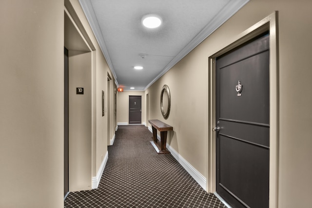 corridor with dark colored carpet and crown molding