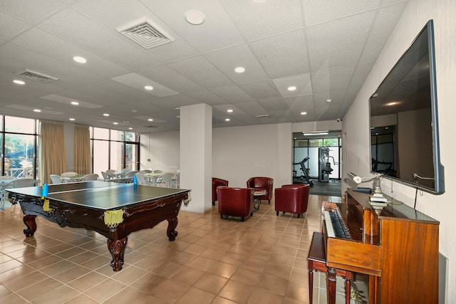 game room with a paneled ceiling, pool table, and light tile patterned flooring