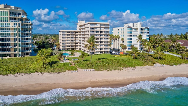 view of building exterior featuring a view of city, a water view, and a view of the beach