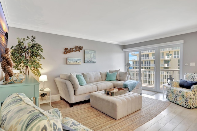 living area featuring ornamental molding, light wood-type flooring, and baseboards