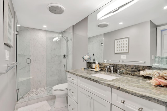 bathroom featuring marble finish floor, a marble finish shower, recessed lighting, toilet, and vanity