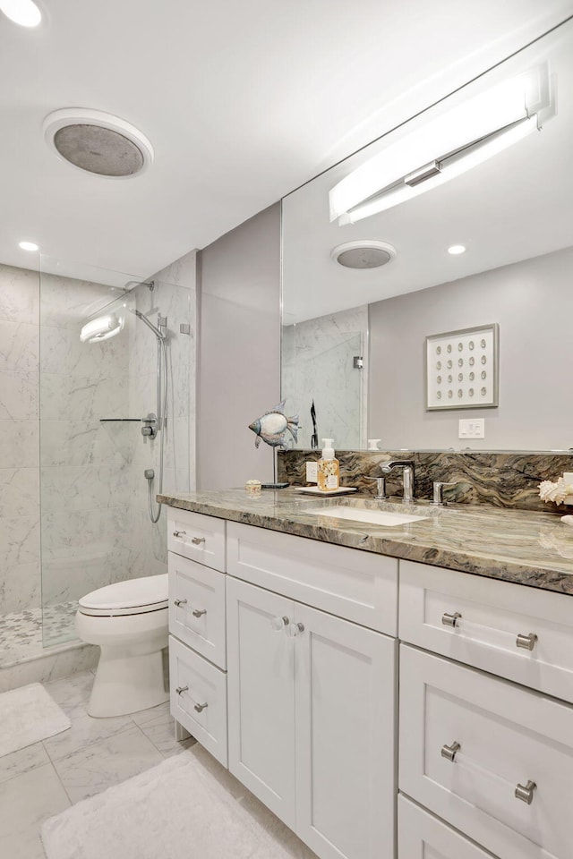 bathroom with toilet, marble finish floor, a marble finish shower, and vanity