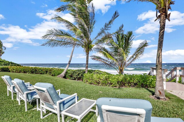 view of yard with a water view and a view of the beach