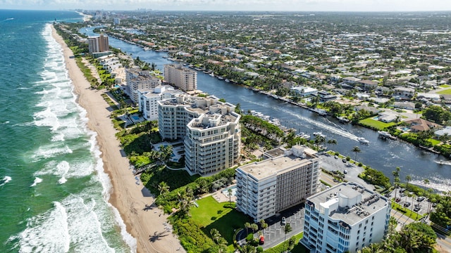 drone / aerial view featuring a water view, a view of city, and a view of the beach