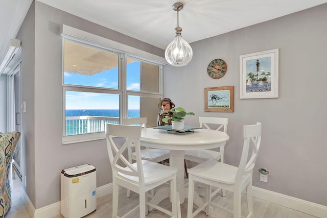 dining room with a water view and baseboards