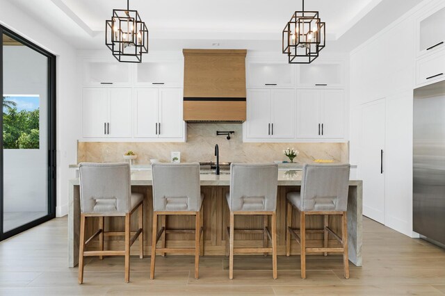 kitchen featuring a center island with sink, a breakfast bar area, and decorative light fixtures