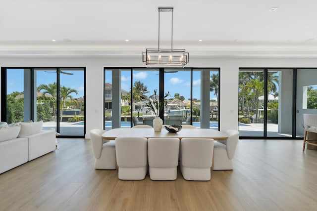 dining space with light wood-type flooring and an inviting chandelier