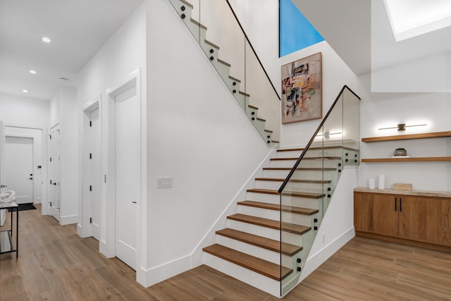 stairway featuring hardwood / wood-style flooring and a skylight