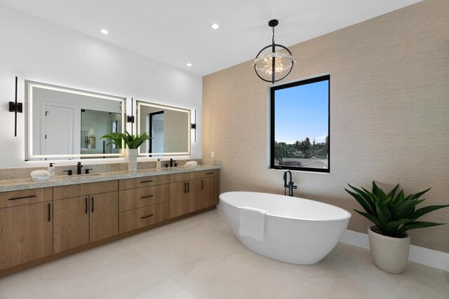 bathroom with a bathing tub, a notable chandelier, and vanity