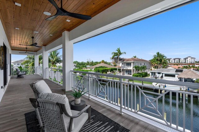 wooden terrace featuring a water view and ceiling fan